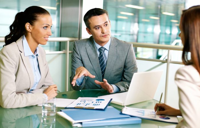 Group of business partners interacting at meeting in office